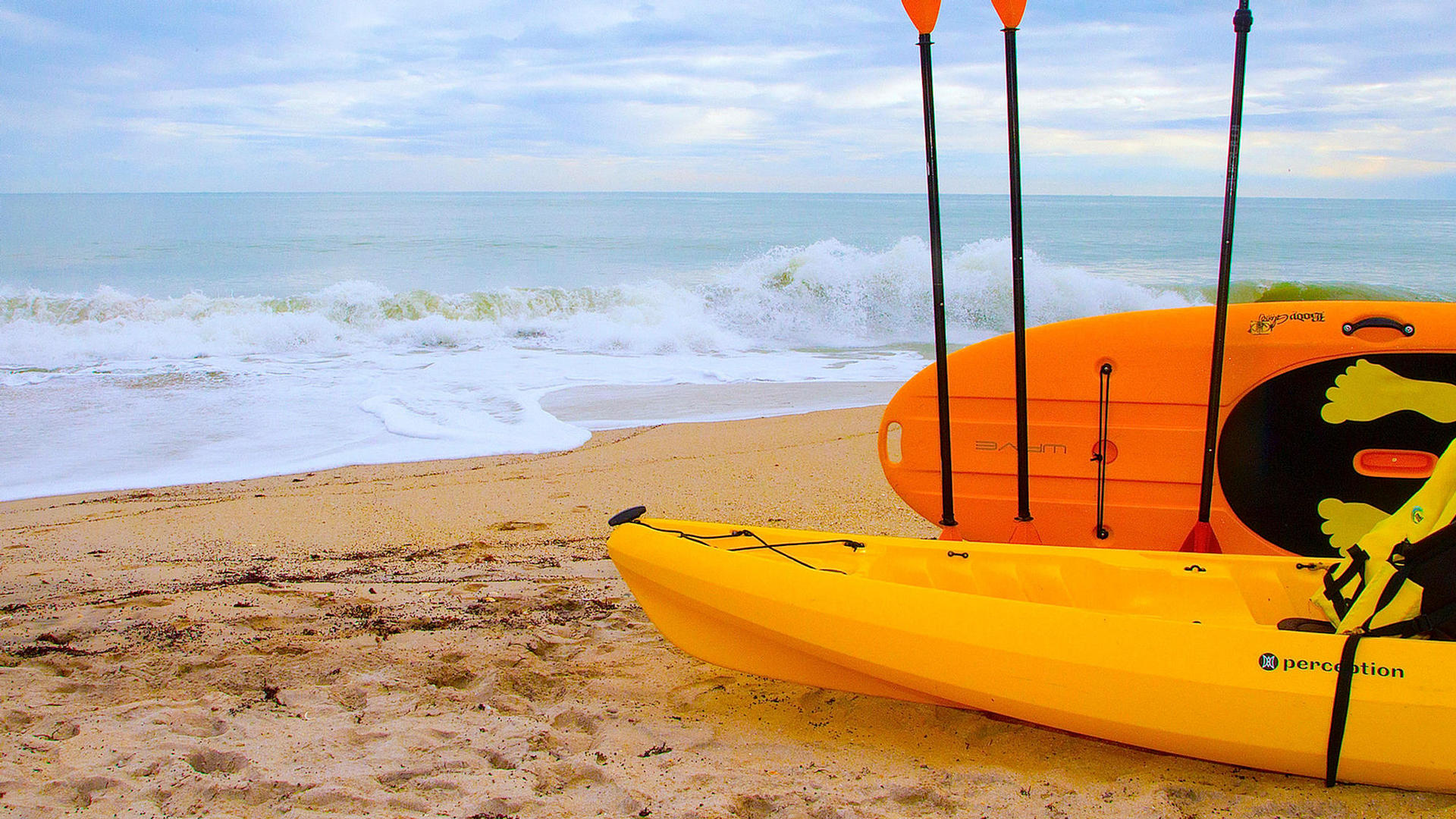 two kayaks laying on vero beach by the ocean