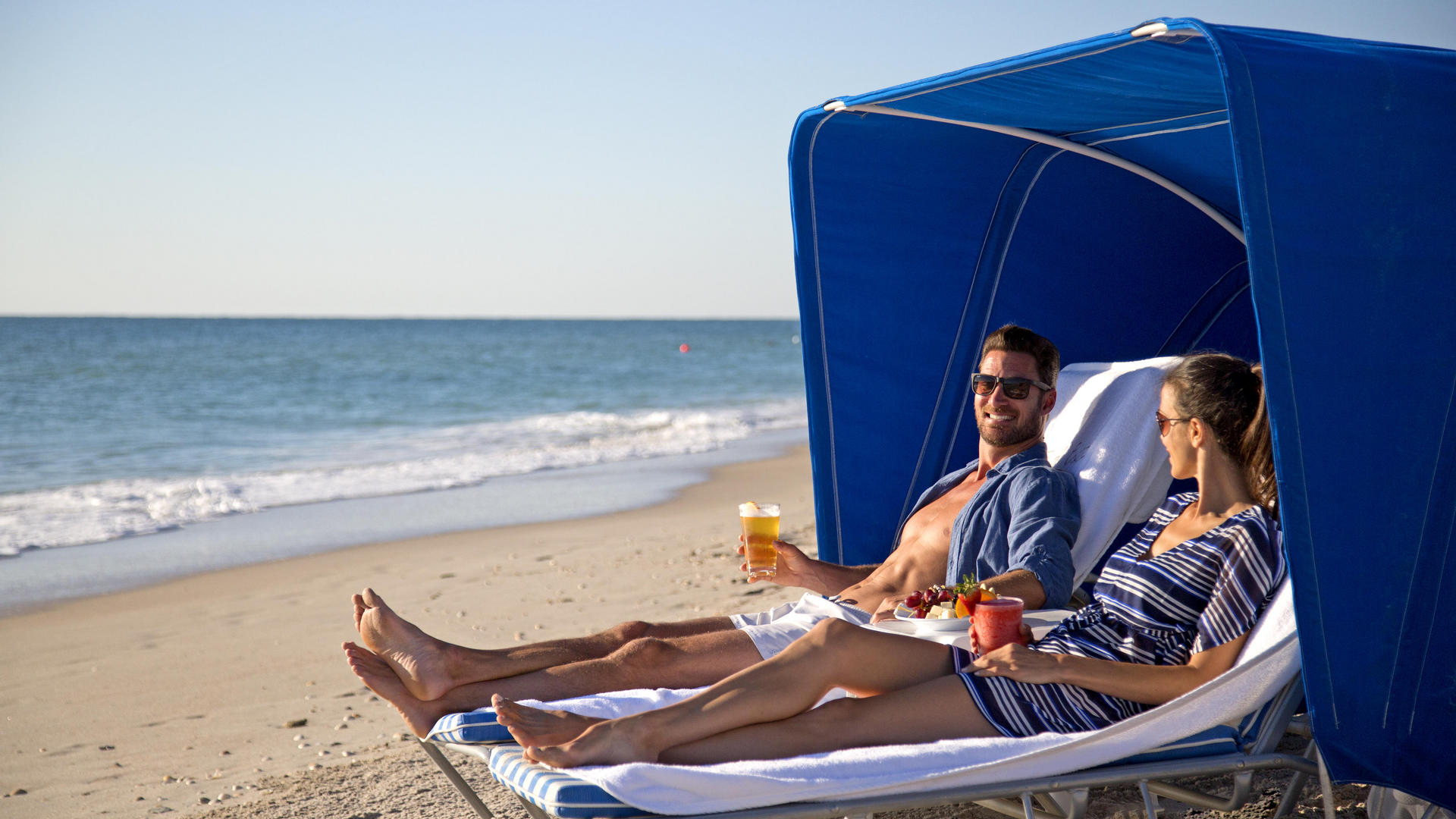 couple lounging under a beach tent at costa d'este