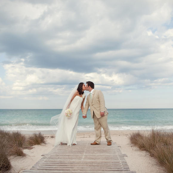 man and woman kissing by the ocean