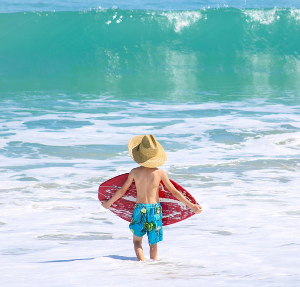 Boy with a skimboard at the beach