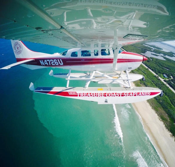 Seaplane flying above the beach