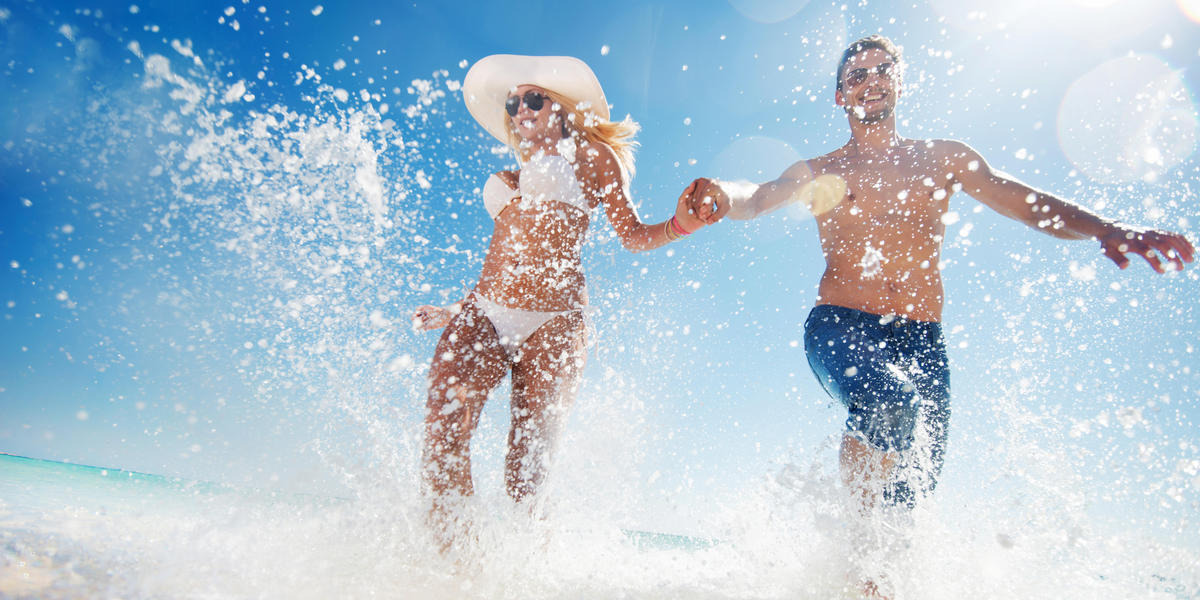 Man and woman running in the ocean waves together